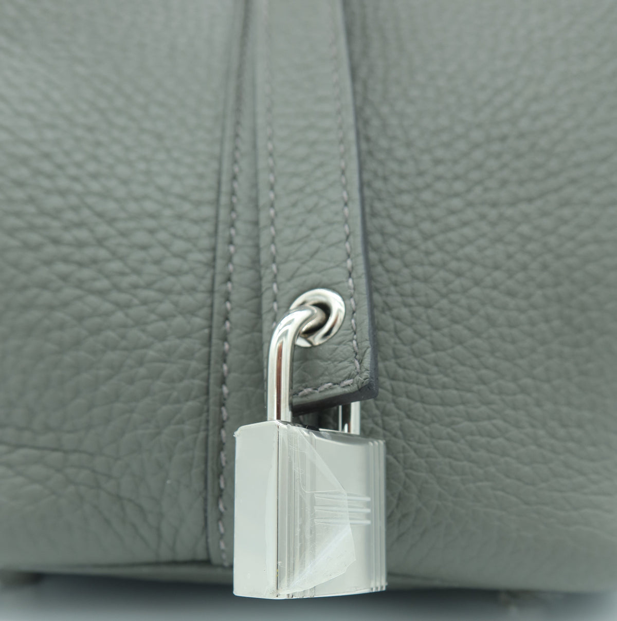 Hermès Taurillon Clemence Picotin Lock 18 PM Etain – Good Condition – Close-up of a silver padlock attached to a gray