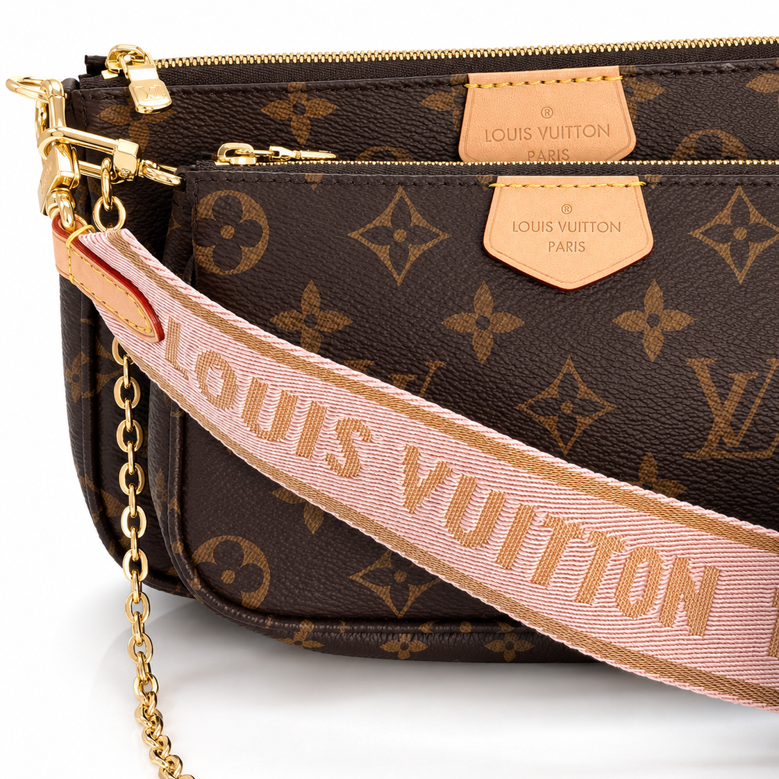 Close-up of Louis Vuitton Multi Pochette Accessoires in brown Monogram canvas showing the pink jacquard strap, leather logo tabs, zippers, and gold-tone hardware