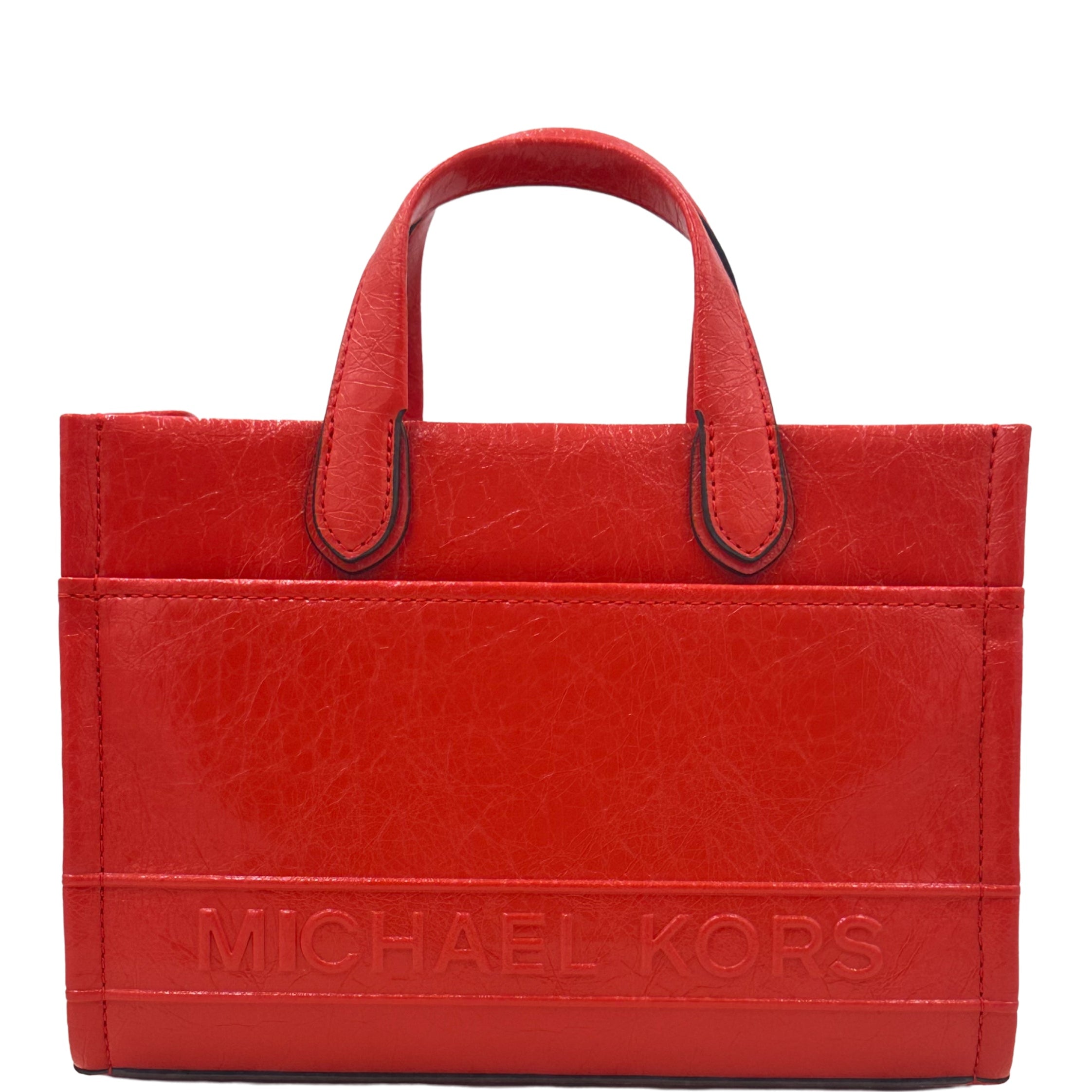 A red Michael Kors Gigi Small East West Messenger bag with top handles and a visible brand embossment.