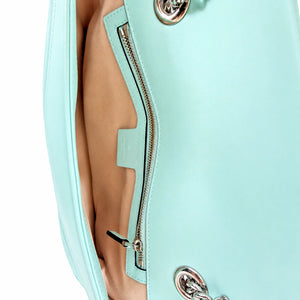 Close-up of a mint green leather handbag showing the interior lining, a zippered pocket, and silver-tone hardware against a white background.
