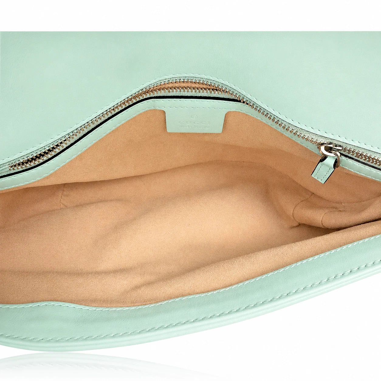 Close-up of the interior of a mint green clutch or pouch, showing a tan fabric lining and a silver zipper with a mint green pull tab.